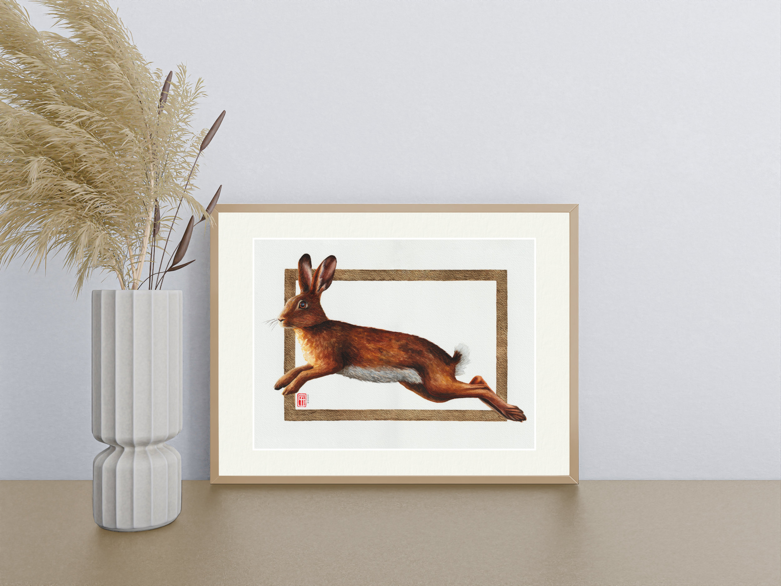 Aquarellgemälde eines Hasen im Sprung mit dem Titel "Golden Leap". Das Gemälde hat einen Rahmen aus Blattmessing (Schlagmetall, Goldimitat).